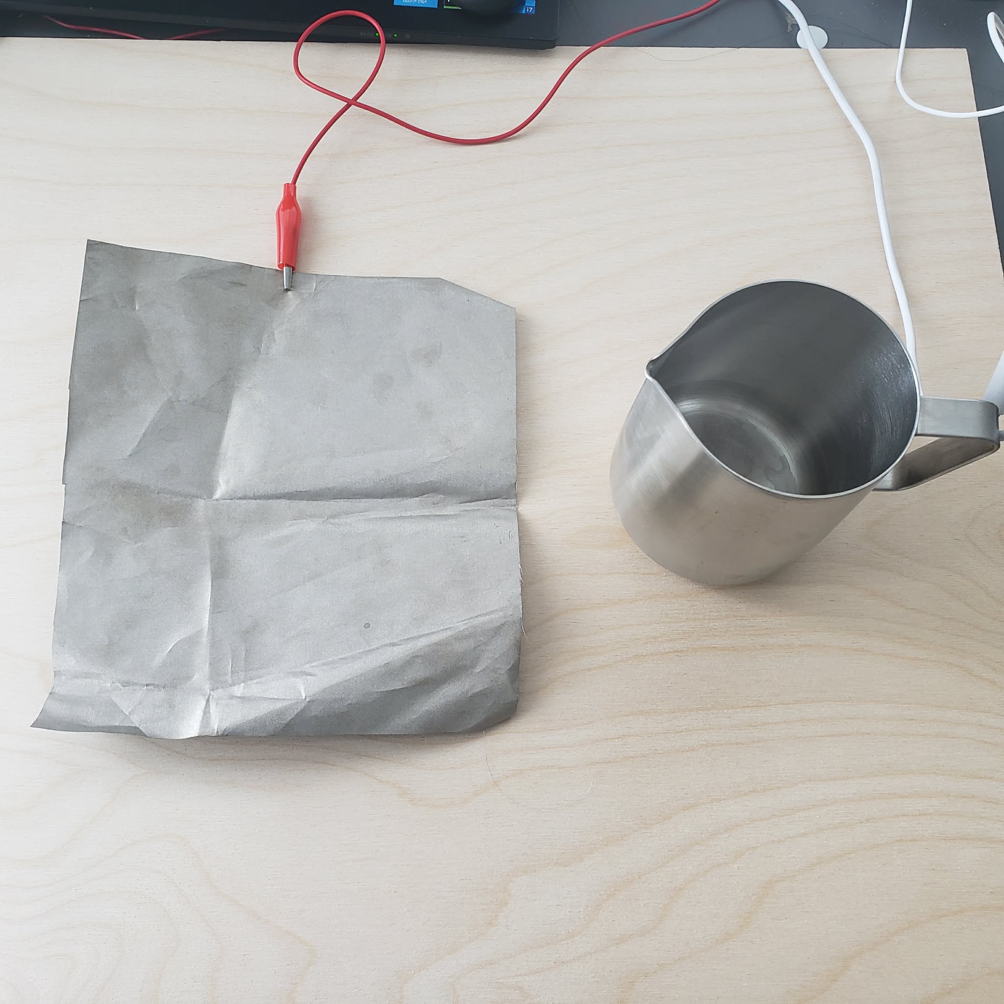 A metal cup and a piece of conductive fabric.